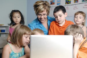 ELC trends with technology teacher using laptop with children